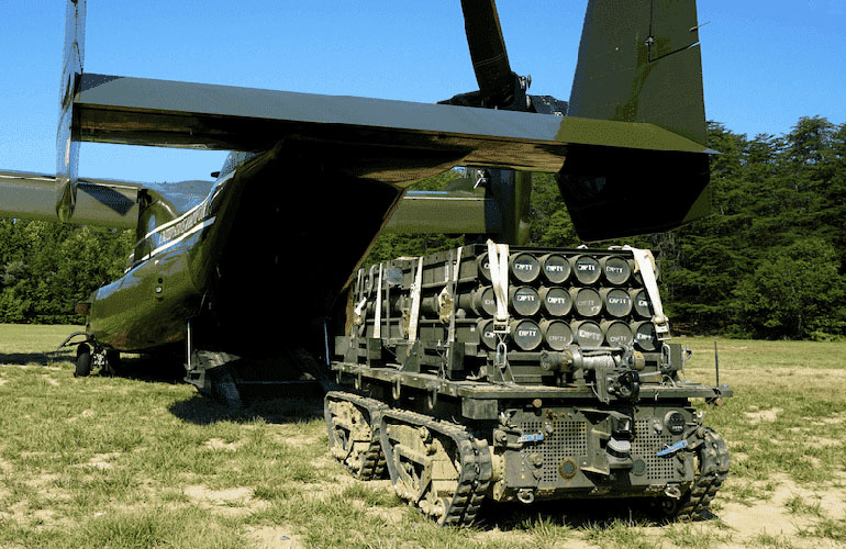 A military-style vehicle fully loaded going into an aircraft.