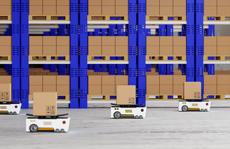 Three white mobile robots with boxes on top of them navigating an aisle with blue racks. 